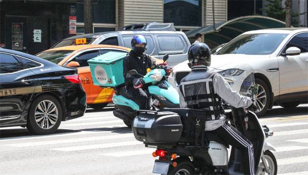 배달 기사들이 배송 시간을 맞추기 위해 차량 사이를 넘나들며 운전하고 있다. 이들 대부분은 산재보험 혜택을 받지 못해 업무 중 사고 위험에 무방비로 노출돼 있다. [이승환 기자]