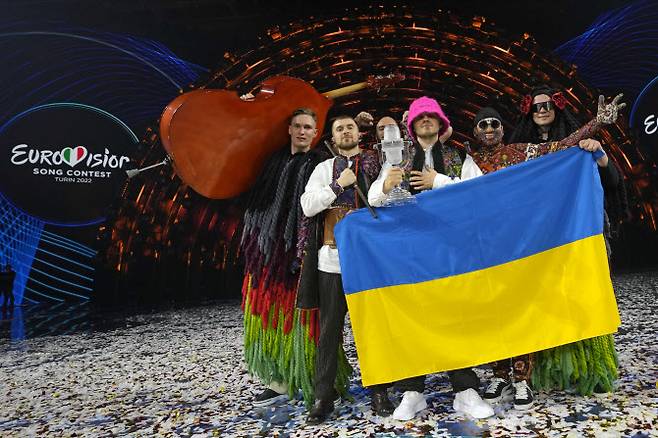 유럽 최대 음악축제 ‘2022 유로비전 송 콘테스트’에 출전한 우크라이나 6인조 남성 밴드 ‘칼루시 오케스트라’가 우승한 뒤 국기를 펼쳐 들고 기뻐하고 있다.(사진=AP/연합뉴스)