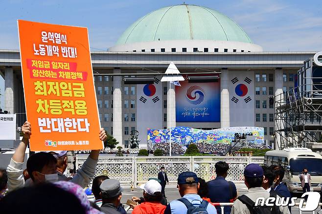 아르바이트 노조원이 10일 서울 여의도 국회에서 열린 제20대 대통령 취임식장 인근에서 ‘최저임금 차등적용 반대’ 피켓을 들어보이고 있다. 2022.5.10/뉴스1 © News1 국회사진취재단