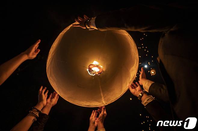 16일(현지시간) 인도네시아 자바의 마겔랑에 있는 보로부두르 사원에서 열린 베삭 데이 기념식에서 신자들이 등불을 띄우고 있다. © AFP=뉴스1 © News1 김예슬 기자