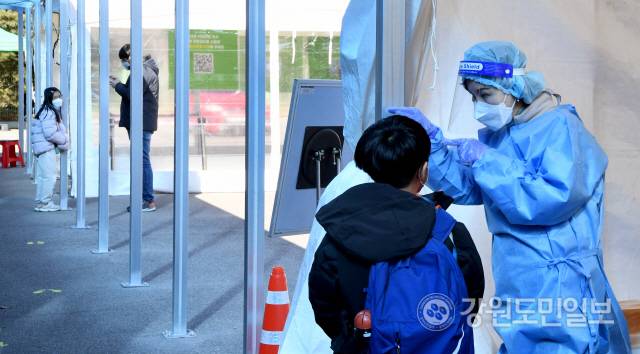 ▲ 춘천시 호반체육관에 마련된 코로나19 선별진료소에서 의료진이 어린이에게 검체 채취 방법을 설명하고 있다. [강원도민일보 자료사진]