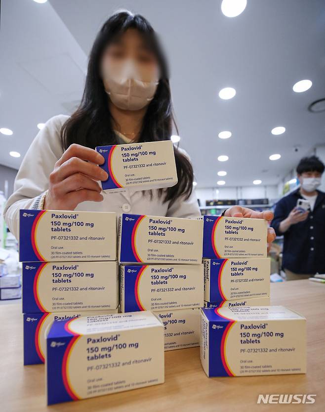 [서울=뉴시스] 권창회 기자 = 16일 오후 서울 시내 한 약국에서 약사가 취재진에게 코로나19 먹는 치료제인 팍스로비드를 보여주고 있다. 오늘부터 코로나19 먹는치료제(경구용 치료제) 처방 대상이 12세 이상 기저질환자로 대폭 확대되고 처방 절차도 간소화된다. 화이자의 '팍스로비드' 처방 대상은 12세 이상, 머크앤드컴퍼니(MSD)의 '라게브리오' 처방 대상은 18세 이상 기저질환자로 확대된다. 2022.05.16. kch0523@newsis.com