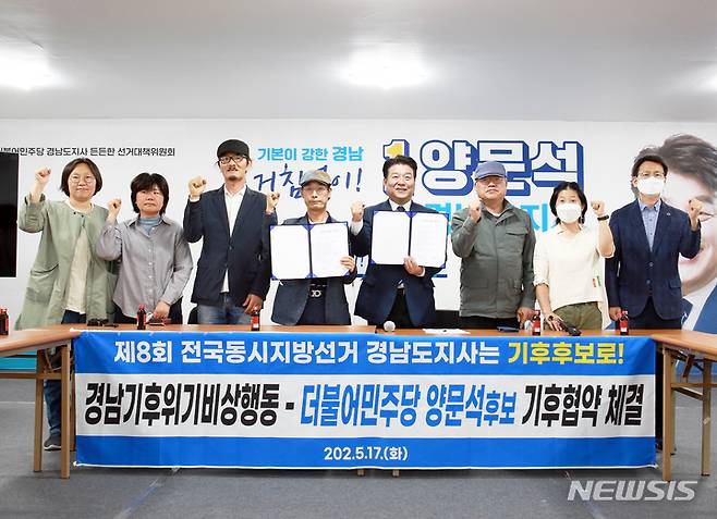 [창원=뉴시스] 홍정명 기자= 양문석(오른쪽) 더불어민주당 경남도지사 후보가 17일 오전 선대위 사무실에서 박종권(왼쪽) 경남기후위기비상행동 공동대표와 기후위기대응 협약을 체결한 후 관계자들과 기념촬영을 하고 있다.(사진=양문석 후보 선대위 제공) 2022.05.17. photo@newsis.com