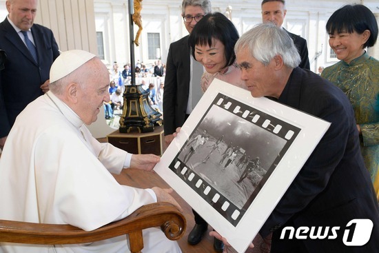 프란치스코 교황이 11일(현지시간) 사진작가 닉 우트와 대화하고 있다. © AFP=뉴스1