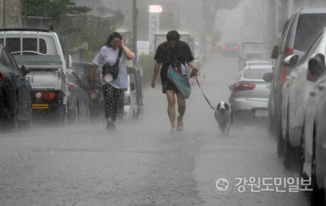▲ 춘천 후평동에서 시민들이 갑작스런 소나기에 비를 맞으며 서둘러 길을 걷고 있다. [강원도민일보]