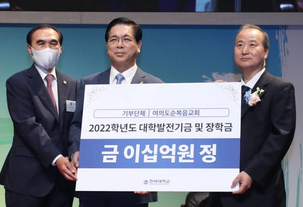 이영훈(가운데) 여의도순복음교회 목사가 17일 경기도 군포 한세대 대강당에서 김정일(오른쪽) 한세대 총장직무대행에게 발전기금을 전달하고 있다. 왼쪽은 신범섭 여의도순복음교회 장로회장. 여의도순복음교회 제공