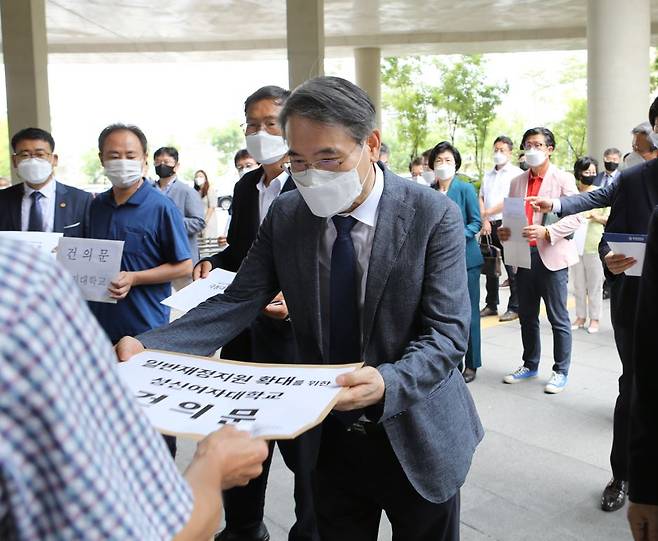 일반재정지원 대상에서 탈락한 성신여자대학교의 박종수 교학부총장이 지난해 8월 정부에 재정지원 필요성과 대학 평가 문제점 등을 설명하는 건의문을 제출하고 있는 모습. [연합]