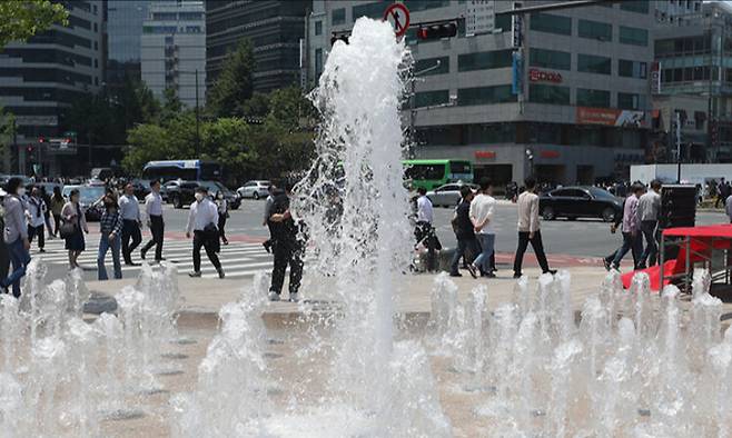 서울 중구 서울시청 앞 광장 분수대를 지나는 시민들이 시원하게 뿜어 나오는 분수를 보며 더위를 식히고 있다. 뉴스1