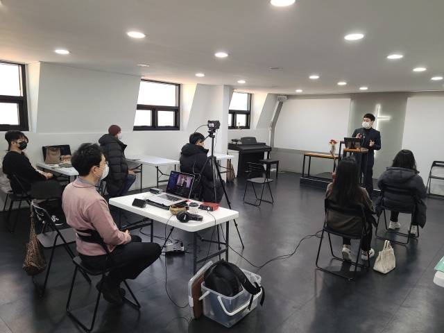 길섶교회 성도들이 오프라인에서 온라인 화면을 보면서 예배를 드리고 있다. 길섶교회 제공