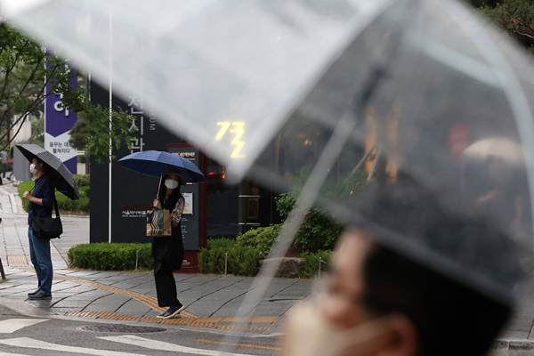 금요일은 전국에 구름이 많으며 오전엔 경기 일부 지역과 수도권, 제주에 비가 조금 오겠다. 사진은 지난 18일 서울 시내에서  우산을 쓰고 횡단보도 앞에 서있는 시민들. /사진=뉴스1
