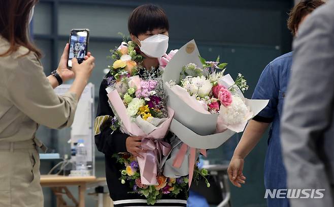 [인천공항=뉴시스] 추상철 기자 = 8년간의 영국생활을 마무리한 영국 여자 프로축구 첼시 위민에서 활약해온 지소연이 19일 오후 인천국제공항을 통해 귀국하며 꽃다발을 받아 들고 있다. 2022.05.19. scchoo@newsis.com