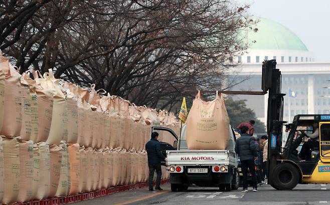 지난 2월 25일 서울 여의도 산업은행 본점 앞 도로에 농민들이 공공 비축벼를 쌓고 쌀 시장 격리를 요구하고 있다. (사진=연합뉴스)