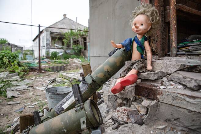 5월 14일 우크라이나 루한스크 루베즈노예의 한 주택 뒷마당에 위치한 옛 우크라이나 육군 요새에 인형하나가 버려진 무기옆에 놓여있다./타스 연합뉴스