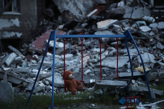 5월 17일 우크라이나 하르키우 살티우카 지구의 파괴된 건물 옆 그네에 테디베어 인형이 놓여있다./로이터 연합뉴스