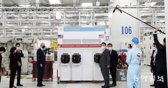 윤석열 대통령과 조 바이든 미국 대통령이 20일 경기 평택 삼성전자 반도체 공장을 방문해 반도체 생산라인을 둘러보며 관계자의 설명을 듣고 있다. 사진 왼쪽은 두 정상이 브리핑을 받는 동안 이재용 삼성전자 부회장이 지나 러몬도 미 상무장관과 별도로 대화를 나누는 모습. 양회성기자 yohan@donga.com