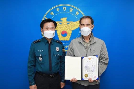 김준철 광주경찰청장이 20일 손님이 놓고 간 지갑을 돌려주러 타지역까지 달려간 택시 기사에게 감사장을 전달한 뒤 기념 촬영하고 있다. [광주경찰청 제공]