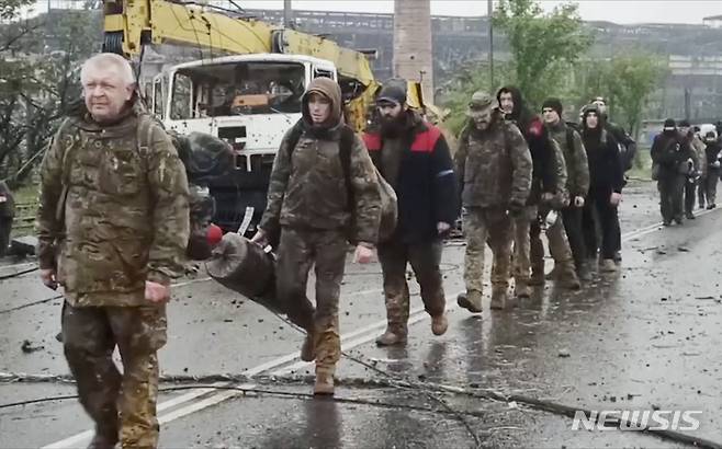 [마리우폴=AP/뉴시스] 19일(현지시간) 우크라이나 동부 도네츠크인민공화국(DPR) 산하 마리우폴의 아조우스탈 제철소에서 우크라이나 군인들이 걸어 나오고 있다. 2022.05.20.
