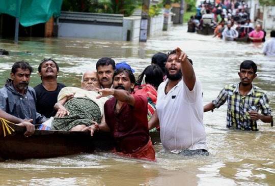지난 2018년 8월 기록적인 홍수가 덮친 인도 남부 케랄라 주에서 주민들이 거동이 불편한 노인을 배에 실어 구조하고 있다. <AP=연합뉴스>