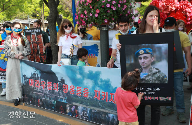 서울 중구 러시아대사관 인근에서 22일 열린 전쟁 반대 집회에서 우크라이나인 줄리아 스물리악(오른쪽)이 전투 중 숨진 친구 데니스 안티포우의 사진을 든 채 눈물을 훔치고 있다. 우철훈 선임기자