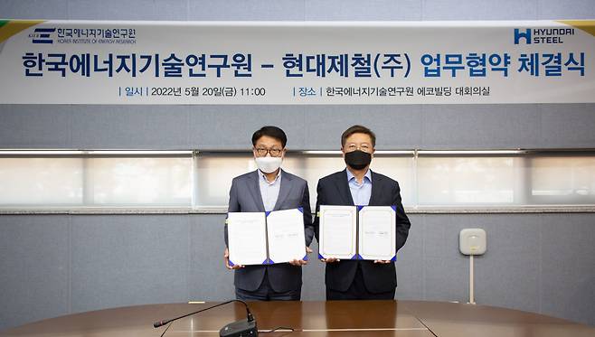 Hyundai Steel CEO Ahn Dong-il (left) and Korea Institute of Energy Research President Kim Jong-nam hold up their signed memorandum of understanding at the KIER in Daejeon on Friday. (Hyundai Steel)