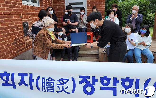 평생 모은 전 재산 기부 성주 박자연 할머니가 가천중학교 학생들에게 장학금을 전달하고 있다. (성주군 제공)2022.5.23/© 뉴스1