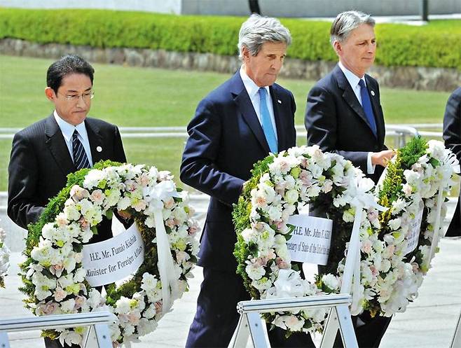 2016년 열린 주요 7개국(G7) 외무장관회의때 사진. 당시 외무상이던 기시다(왼쪽) 총리가 존 케리(가운데) 당시 미국 국무장관과 함께 일본 히로시마(廣島) 평화기념공원을 방문해 원폭 희생자 위령비에 헌화하는 모습. 오른쪽은 필립 해먼드 당시 영국 외무장관.
