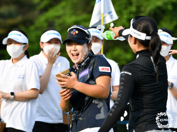 한국여자프로골프(KLPGA) 투어 2년차 홍정민이 22일 강원 춘천 라데나 골프클럽에서 끝난 두산 매치플레이 챔피언십에서 이예원을 1홀 차로 따돌리고 데뷔 첫 승을 신고한 뒤 동료들의 축하 물세례를 받으며 함박웃음을 짓고 있다.KLPGA 제공