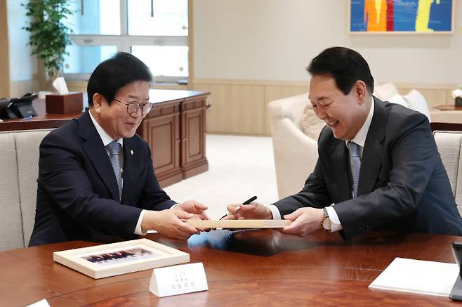 윤석열 대통령이 24일 오후 용산 대통령실 청사 집무실에서 임기 만료를 앞둔 박병석 국회의장을 비롯한 21대 전반기 국회의장단을 접견, 박 의장에게 조 바이든 미국 대통령 환영 만찬 당시 찍은 기념사진이 든 액자를 선물하고 있다. 연합뉴스