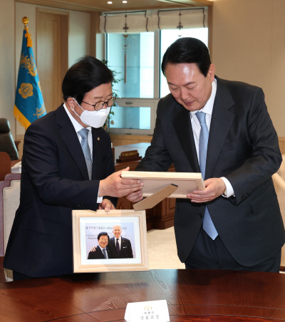 박병석 의장에게 바이든과 찍은 사진 선물 윤석열 대통령이 24일 용산 대통령실 청사 집무실에서 21대 전반기 국회의장단과 만나 박병석 국회의장(왼쪽)에게 조 바이든 미국 대통령 환영 만찬 때 찍은 기념사진을 선물하고 있다. 연합뉴스