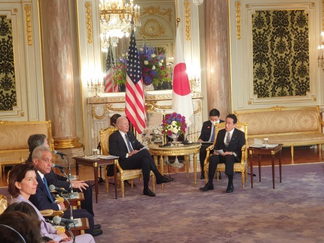 기시다 후미오 일본 총리(오른쪽)과 조 바이든 미국 대통령이 정상회담에서 대화하고 있다. 람 이매뉴얼 주일 미국대사와 지나 러몬도 상무장관이 사진 왼쪽 아래에 잡혔다.