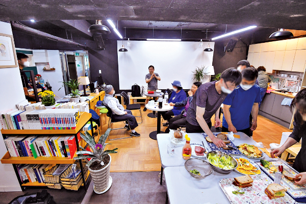 서울 관악구 대학동에 거주하는 주민들이 주방 식탁 도서 등이 마련된 ‘참 소중한…’ 공간에서 샌드위치를 만들어 먹으며 교제를 나누고 있다.  신석현 포토그래퍼