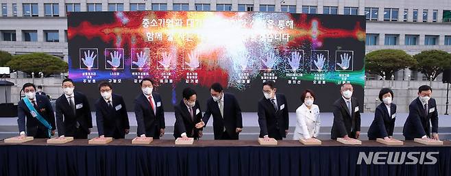 [서울=뉴시스] 전신 기자 = 윤석열 대통령이 25일 서울 용산 대통령실 청사 앞 잔디광장에서 열린 2022 대한민국 중소기업인대회에서 대·중소기업 간 공정과 상생을 통한 신동반성장을 다짐하는 핸드프린팅 퍼포먼스를 하고 있다. 왼쪽부터 주보원 삼흥열처리 대표, 구광모 LG그룹 회장, 강삼권 벤처기업협회장, 최태원 SK그룹 회장, 김기문 중소기업중앙회장, 윤석열 대통령, 이재용 삼성전자 부회장, 이정한 한국여성경제인협회장, 정의선 현대자동차그룹 회장, 오세희 소상공인연합회장, 신동빈 롯데그룹 회장. 2022.05.25. photo1006@newsis.com