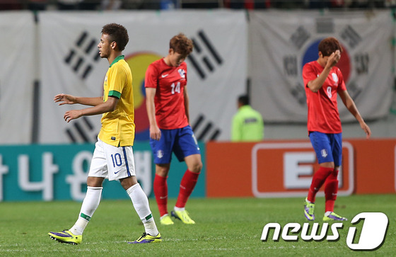 12일 오후 서울월드컵경기장에서 열린 축구 국가대표 평가전 한국과 브라질의 경기에서 2:0으로 승리한 브라질 네이마르 뒤로 손흥민과 윤일록이 고개를 숙인 채 퇴장하고 있다. 2013.10.12/뉴스1