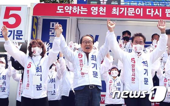 22일 영천공설시장앞에서 열린 무소속 최기문 영천시장 후보 유세에서 방송인 이상벽씨가 최 후보 부부와 손을 들고 지지를 호소하고 있다. (최기문 캠프 제공)2022.5.22/뉴스1 © News1 정우용 기자