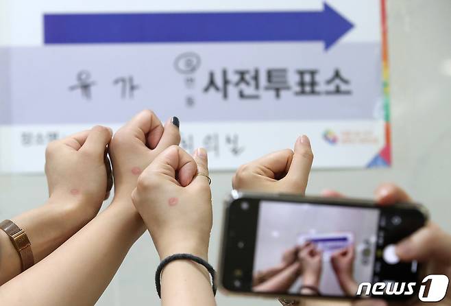 제8회 전국동시지방선거 사전투표 첫날인 지난 27일 오후 대구 달성군 유가읍 행정복지센터에 마련된 사전투표소에서 투표를 마친 대학생 유권자들이 투표 인증샷을 남기고 있다. 2022.5.27/뉴스1 © News1 공정식 기자