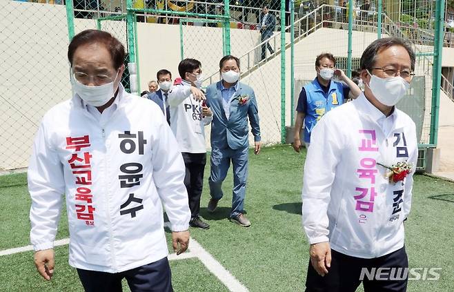 [부산=뉴시스] 하경민 기자 = 제8회 전국동시지방선거를 열흘 앞둔 22일 부산 부산진구 개성고등학교에서 열린 총동창회 체육대회에 참석한 하윤수(왼쪽) 부산교육감 후보와 김석준 부산교육감 후보가 시축을 하기 위해 이동하고 있다. 2022.05.22. yulnetphoto@newsis.com