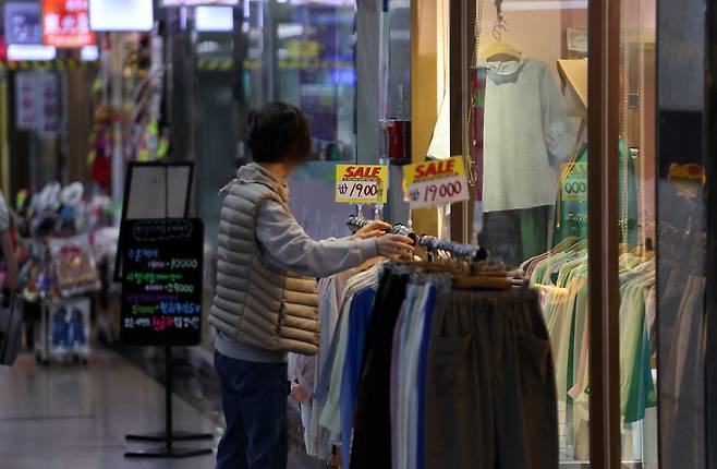 29일 오후 서울 명동 인근 지하상가 한 옷 가게에서 상인이 옷을 진열하고 있다. 연합뉴스