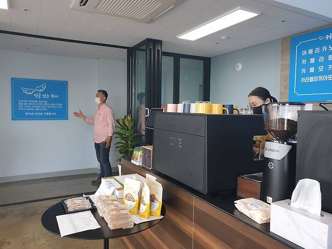 김성국 단장이 지난 26일 안내문 앞에서 천사마을카페를 설명하고 있다. 박임근 기자