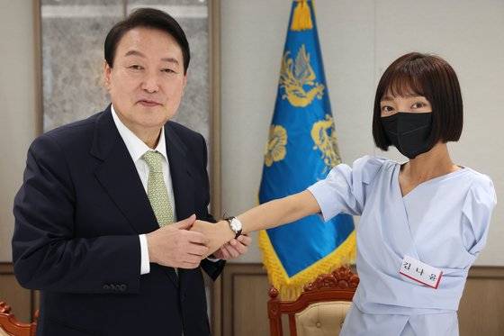 윤석열 대통령이 25일 용산 대통령실에서 취임식에 참석했던 국민희망대표들에게 대통령 기념시계를 선물하고 오찬을 함께 했다. 윤 대통령이 한팔 보디빌더로 WBC 피트니스 월드바디 클래식에서 4관왕을 차지한 김나윤씨에게 시계를 채워주고 있다. 대통령실사진기자단