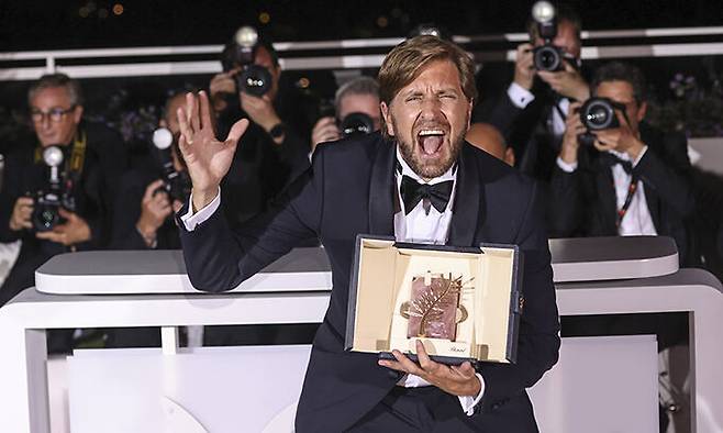 스웨덴의 루벤 외스틀룬드 감독이 28일(현지시간) 프랑스 칸에서 열린 제75회 칸국제영화제 시상식에서 그의 작품 ''슬픔의 삼각형''(TRIANGLE OF SADNESS)으로 황금종려상을 수상한 뒤 기념촬영을 하며 환호하고 있다. AP연합뉴스