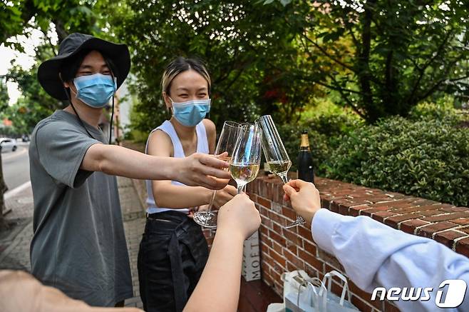 코로나 봉쇄령이 완화된 상하이에서 외출 허가를 받은 주민들이 건배하고 있다. © AFP=뉴스1 © News1 우동명 기자