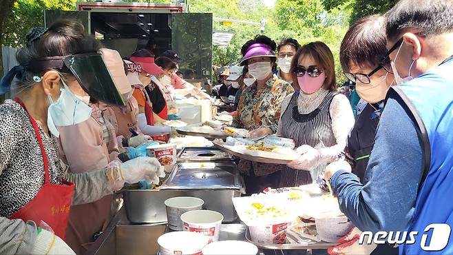 자원봉사자들은 몸이 불편한 노인들을 위해 큰쟁반에 음식을 올리고 배달 준비를 하고 있다. 2022.5.31/뉴스1 © News1 이성덕 기자