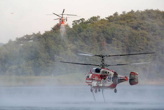 31일 경남 밀양시 북부면 춘화리에서 산불이 발생하여 인근 저수지에서 산림청 헬기가 화재진압을 위한 급수를 하고 있다./뉴스1