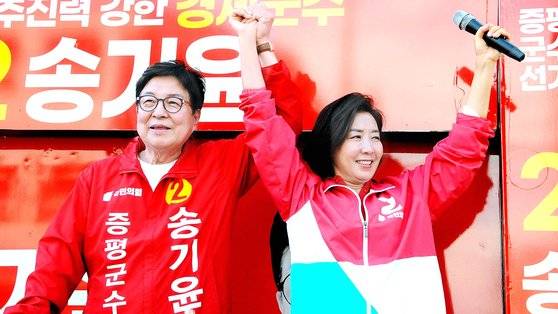 나경원 국민의힘 전 의원이 29일 오후 증평새마을금고 앞에서 열린 합동유세에서 지지를 당부하는 연설을 한 뒤 송기윤 후보와 손을 들어올리고 있다. 뉴스1