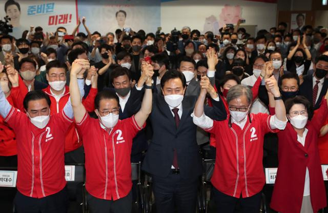 오세훈(앞줄 가운데) 국민의힘 서울시장 후보가 1일 오후 서울 중구 한국프레스센터에 마련된 선거사무소에서 ‘제8회 전국동시지방선거’ 방송 3사(KBS·MBC·SBS) 출구조사 결과가 나오자 선대위 관계자들과 손을 들어올리고 있다. 오대근 기자