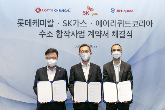 From left, Hwang Jin-koo, CEO of Lotte Chemical’s basic material division, Yoon Byung-suk, CEO of SK gas, and Nicolas Foirien, CEO of Air Liquide Korea, pose for a photo after signing an agreement to build a hydrogen fuel cell plant Thursday at Lotte World Tower in southern Seoul. [LOTTE CHEMICAL]