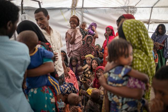 지난달 17일 에티오피아 세메라시에서 100㎞ 떨어진 국내실향민(IDP) 캠프에서 티그라이에서 탈출한 여성들이 아이들을 안고 서 있다. 세메라=AFP 연합뉴스
