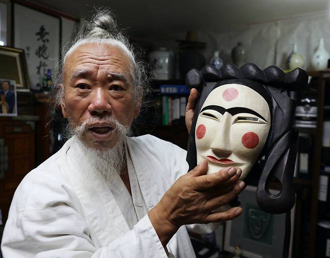 Kim Jong-heung, 67, Hahoe’s sanju, or village spiritual leader, holds a bride mask in Hahoe, Andong, North Gyeongsang Province. Photo © Hyungwon Kang