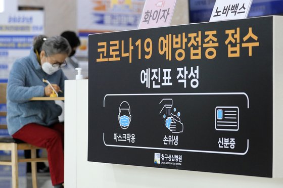 지난달 14일 오후 서울 은평구 청구성심병원에서 한 시민이 코로나19 백신 4차 접종에 앞서 서류를 작성하고 있다. 뉴스1
