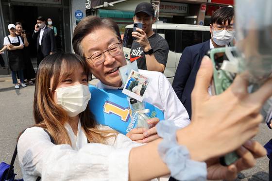 (인천=뉴스1) 조태형 기자 = 이재명 더불어민주당 총괄선거대책위원장이 20일 인천 계양구 계산3동 일대에서 시민들과 인사를 나누던 중 한 지지자의 사진 요청에 응하고 있다. 2022.5.20/뉴스1